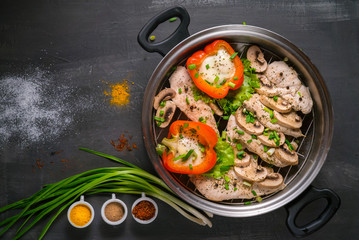 healthy food steamed chicken with mushrooms and vegetables on a black background