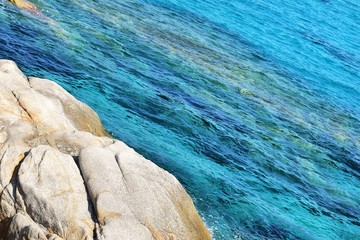 Obraz na płótnie Canvas Amazing azure sea water and rocks. Beautiful natural beach with white stones and turquoise water. Halkidiki Greece Blue Flag Beach. Coral reef in the sea. White rocks and blue transparent ocean 
