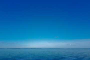 The surface of the lake, blue water, sun glare on the surface of the sea on a warm summer day