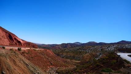 Fototapeta premium Bright landscape of Morocco, breathtaking curves of mountains, stunning combination of hills & farm land,inadvertent distribution of houses & huts, raw impression of pure nature.