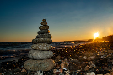 Pyramid of stones on the beach at sunset,