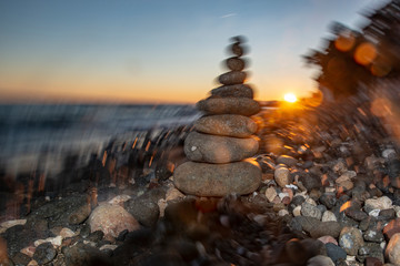 Pyramid of stones on the beach at sunset,