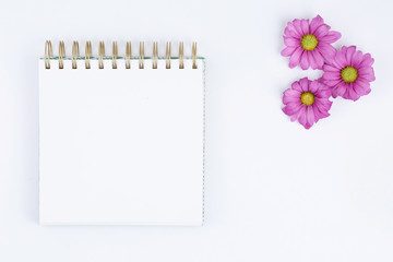 Open spiral notepad with purple flowers.