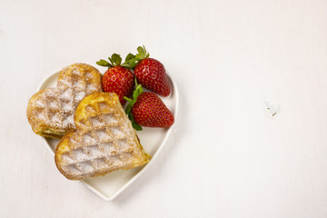 Waffle biscuits in shape of heart on rustic background for Valentines day