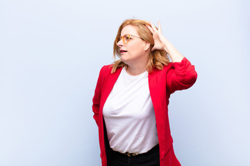 middle age woman looking serious and curious, listening, trying to hear a secret conversation or...
