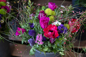 Colorful spring bouquet from fresh cut flowers - anemone coronaria, chrysanthemums, sea lavender - flowers gift.