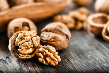 Whole walnuts on dark board, Walnut kernels in wood rustic bowl.