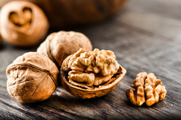 Whole walnuts on dark board, Walnut kernels in wood rustic bowl.