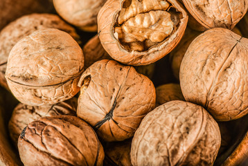 Whole walnuts on dark board, Walnut kernels in wood rustic bowl.