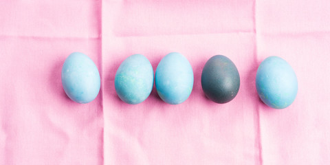 Blue easter boiled eggs on pink table cloth