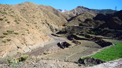 Bright landscape of Morocco, breathtaking curves of mountains, stunning combination of hills & farm land,inadvertent distribution of houses & huts, raw impression of pure nature.