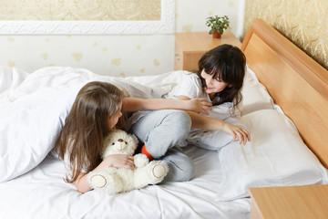 sisters playing in the bedroom on the bed