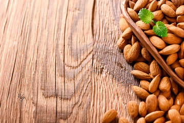 Almond nuts on wooden table top view. Fresh almonds copy space.