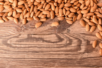 Almond nuts on wooden table top view. Fresh almonds copy space.