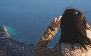 a girl photographs a view of the sea