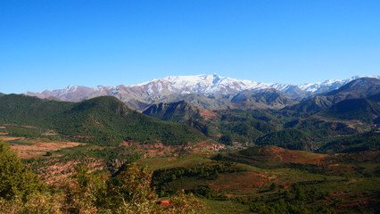 Naklejka premium Bright landscape of Morocco, breathtaking curves of mountains, stunning combination of hills & farm land,inadvertent distribution of houses & huts, raw impression of pure nature.