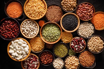 Fototapeten Legumes, a set consisting of different types of beans, lentils and peas on a black background, top view. The concept of healthy and nutritious food © pbd Studio