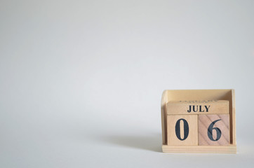 July 6, Empty white background with number cube on the table.