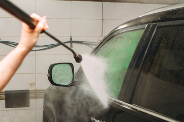 An employee of the car wash thoroughly washes conducts detaling and applies protective equipment to...