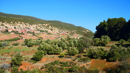 Fototapeta na wymiar Bright landscape of Morocco, breathtaking curves of mountains, stunning combination of hills & farm land,inadvertent distribution of houses & huts, raw impression of pure nature.