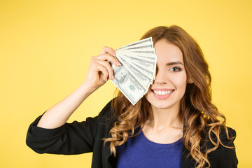 happy woman with money in hand, yellow background