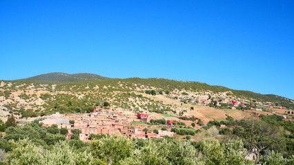 Fototapeta premium Bright landscape of Morocco, breathtaking curves of mountains, stunning combination of hills & farm land,inadvertent distribution of houses & huts, raw impression of pure nature.