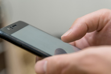 holds a mobile phone in his hand. smartphone in the hands of a man close-up