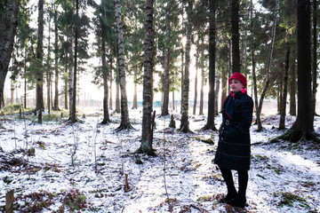 Woman in a red hat against a large dense forest.