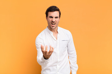 young handsome man looking angry, annoyed and frustrated screaming wtf or what‚Äôs wrong with...