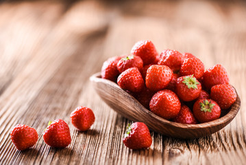 Whole strawberries in wooden bowl. Fresh nice strawberries on wooden table. Juice strawberry fine collected.