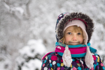 portrait caucasian Pretty happy little girl in modern winter clothes playing in the snow and enjoying winter