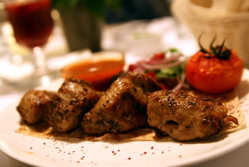 juicy pieces of barbecue and grilled vegetables on a plate close up