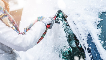 Woman cleaning snow from windshield, Scraping frozen ice glass. Winter car clean front windows.