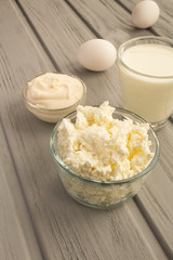 Homemade farm dairy products on the grey wooden background. Location vertical.