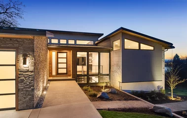 Foto op Canvas Beautiful modern style luxury home exterior at sunset with glowing interior lights. © bmak