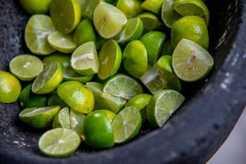 split lemons for tacos in molcajete of Mexican type mud