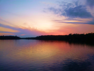 Fototapeta na wymiar Sunrise making an orange and purple sky over the lake