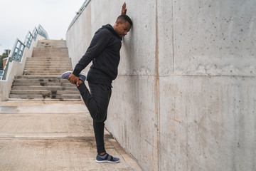 Athletic man stretching legs before exercise.