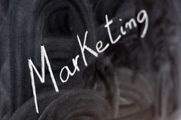 La palabra marketing escrita en la pizarra con una tiza, desenfocada
