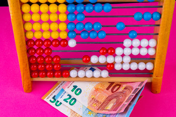 Purple background with abacus and euro banknotes