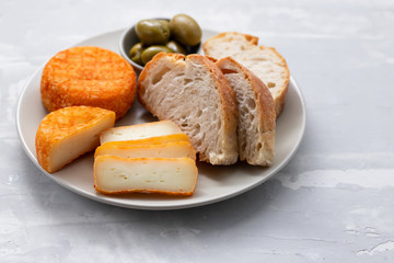 appetizer cheese with bread and olives on dish