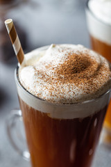 Iced coffee in a tall glasses with cream poured over