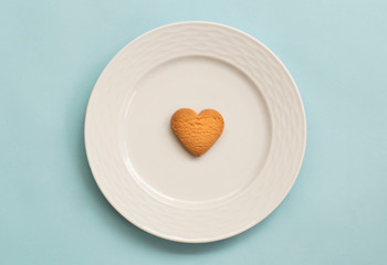 heart cookies in white plate on pink background