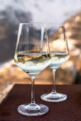 Two glasses with white wine and reflections of mountains. Italian Alps.