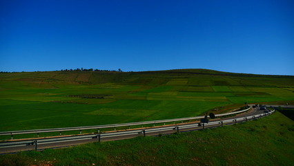 Bright landscape of Morocco, breathtaking curves of mountains, stunning combination of hills & farm land,inadvertent distribution of houses & huts, raw impression of pure nature.