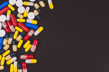 pile of multicolored tablets on a black background