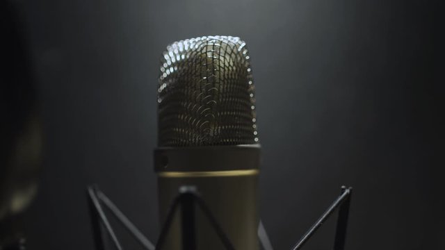 Panning over voice recording microphone - close up - dark scene