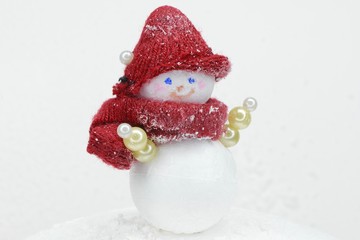 little snowman in a striped hat and scarf
