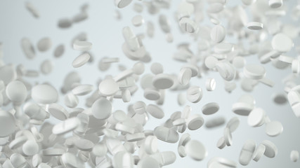 Freeze motion of white pills on white background.