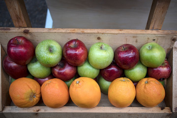 Red, green apples and oranges for sale in the street market